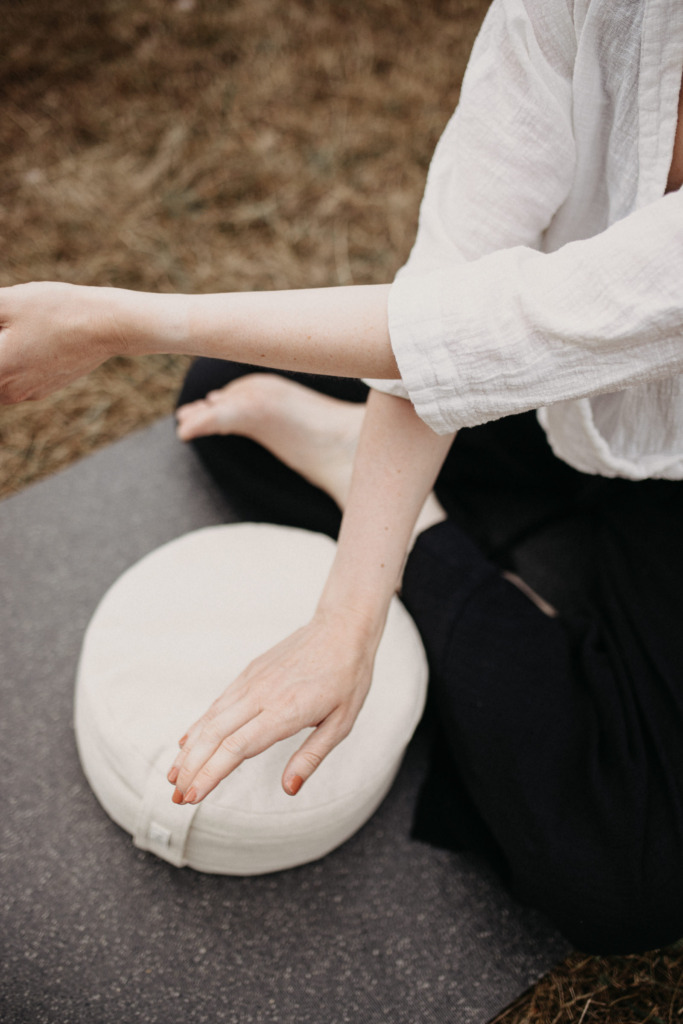 Ruhiges Portrait einer Yogalehrerin in einer Yin Yoga Haltung draußen in der Natur